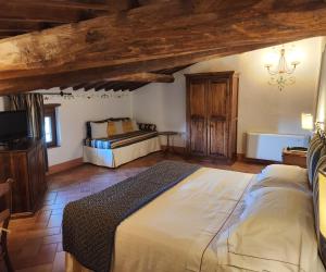 1 dormitorio con 1 cama y TV. en Villa Curina Resort en Castelnuovo Berardenga