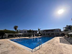 a large swimming pool with chairs and a building at Spacious Beachfront Two-Bedroom Apartment in Caesar Beach in Boghaz