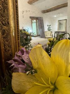 Confrançon的住宿－Domaine des Granges Neuves，坐在镜子前的黄色花