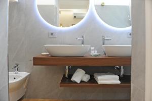 a bathroom with two sinks and a mirror at Mom Apartment Rooms&Suites in Tivoli +66 photos