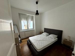 a bedroom with a white bed and a window at Appartement in Belfort