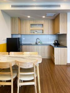 a kitchen with a table and some chairs and a counter at Tony Apartment -FLC Sea Tower Quy Nhon in Quy Nhon