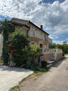 a large house with a balcony and a tree at Sunny House in Čapljina