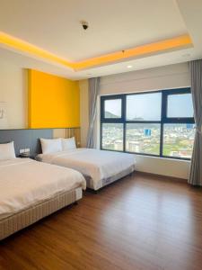 a hotel room with two beds and a large window at Tony Apartment -FLC Sea Tower Quy Nhon in Quy Nhon
