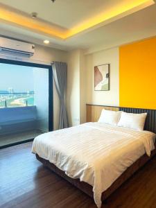 a bedroom with a large bed and a large window at Tony Apartment -FLC Sea Tower Quy Nhon in Quy Nhon