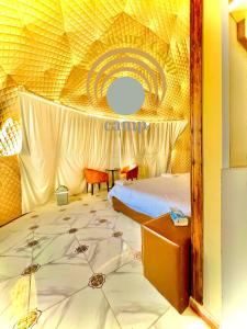 a bedroom with a large bed with a ceiling at Siwar Luxury Camp in Wadi Rum