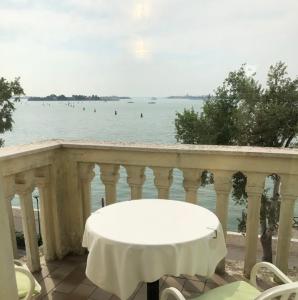 a table and chairs on a balcony overlooking the water at Hotel Russo Palace in Venice-Lido