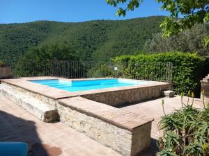 a swimming pool with a stone wall around it at Montanari Agrivillage in Narni