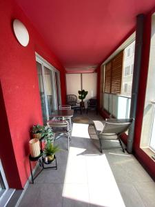 a balcony with chairs and a red wall at Élégant T3 au Panier Vieux Port avec Terrasse Privée et Parking in Marseille