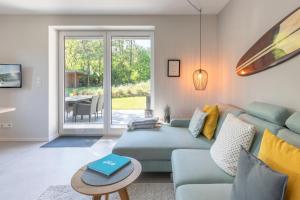 a living room with a blue couch and a table at Hus Dree in Sankt Peter-Ording