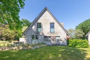 an old stone house with a grass yard at Hus Dree in Sankt Peter-Ording