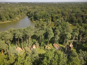 Huttopia Rambouillet في رامبوييه: اطلالة جوية على نهر فيه بيوت واشجار