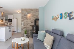 un salon avec un canapé bleu et une table dans l'établissement Hus Veer, à Sankt Peter-Ording 8 autres photos