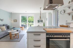 Il comprend une cuisine et un salon avec un canapé et une cuisinière. dans l'établissement Hus Veer, à Sankt Peter-Ording