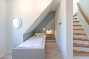 un lit dans une chambre avec un escalier dans l'établissement Hus Veer, à Sankt Peter-Ording