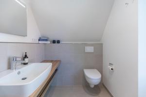 une salle de bain avec un lavabo et des toilettes dans l'établissement Hus Veer, à Sankt Peter-Ording