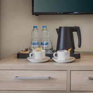einer Theke mit zwei Tassen und Wasserflaschen in der Unterkunft The Howard Hotel in Sliema
