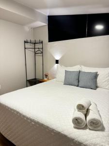Un dormitorio con una cama blanca con toallas. en Suítes Viver Arraial do Cabo, en Arraial do Cabo