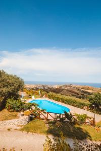 an overhead view of a swimming pool with the ocean in the background at Calàmi - Villa Romeo - Private Apartments with Pool, Seaview & Olive Grove in Santa Caterina Dello Ionio Marina