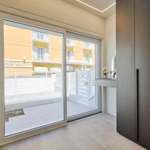 una porta scorrevole in vetro con vista su un balcone di The Twins 2 Luxury Home - Lungomare Viale Milano 20 a Riccione
