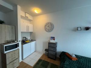 a small kitchen with a clock on the wall at Business Appartement Mainz Duo in Mainz