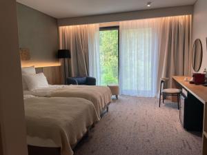 Cette chambre comprend 2 lits et une fenêtre. dans l'établissement Balvanyos Resort (Grand Hotel Balvanyos), à Bálványos