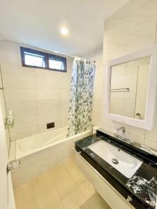La salle de bains est pourvue d'un lavabo et d'une baignoire. dans l'établissement Boss Mansion, à Bangkok