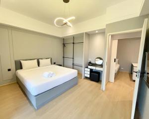 - une chambre avec un grand lit blanc et une salle de bains dans l'établissement Boss Mansion, à Bangkok