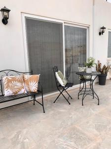 a patio with a bench and chairs and a table at Terrace Room on Parish Street in Luqa