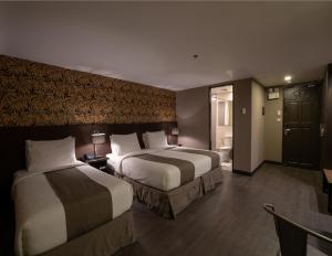 Pokój hotelowy z 2 łóżkami i łazienką w obiekcie GT Hotel Jaro w mieście Iloilo
