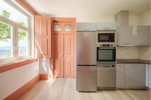 a kitchen with stainless steel appliances and a window at Feel Discovery Villa Aura Douro Valley in São Martinho de Mouros