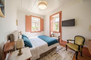 a bedroom with a bed and a desk and a chair at Feel Discovery Villa Aura Douro Valley in São Martinho de Mouros +35 photos