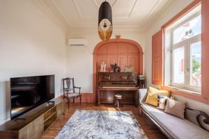 a living room with a piano and a couch at Feel Discovery Villa Aura Douro Valley in São Martinho de Mouros