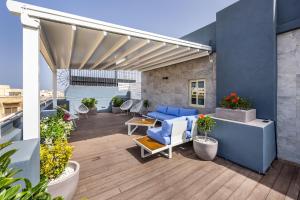 eine Terrasse mit blauen Möbeln auf einem Gebäude in der Unterkunft The Howard Hotel in Sliema