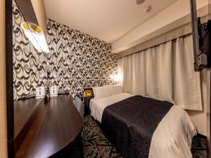 a hotel room with a bed and a black and white wallpaper at APA Hotel Kanazawa Chuo in Kanazawa