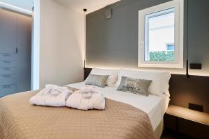 una camera da letto con un letto e asciugamani di The Twins 2 Luxury Home - Lungomare Viale Milano 20 a Riccione