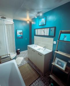 a bathroom with a white sink and a blue wall at Loft industriel 150 m2 10min du circuit in Le Mans