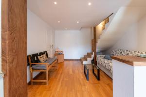 een woonkamer met een trap en een bank bij Les Sapins in Rochefort-en-Terre