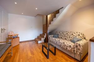 een woonkamer met een bank en een trap bij Les Sapins in Rochefort-en-Terre