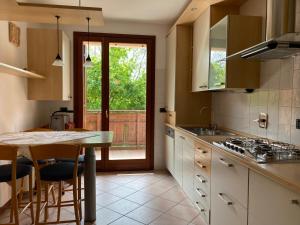 Una cocina con encimera y mesa con sillas. en La Foresteria, en Feletto Umberto