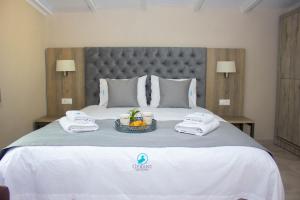 a bed with towels and a tray of fruit on it at Potamos Studios by GERANI in Órmos