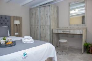 a bedroom with a bed with a vanity and a mirror at Potamos Studios by GERANI in Órmos