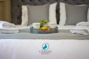 a bed with a tray with two cups and a fruit on it at Potamos Studios by GERANI in Órmos