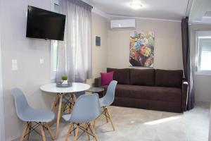 a living room with a couch and a table and chairs at Potamos Studios by GERANI in Órmos