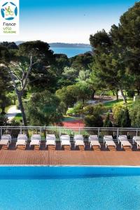 - un ensemble de chaises longues installées à côté de la piscine dans l'établissement Hôtel Club la Font des Horts, à Hyères