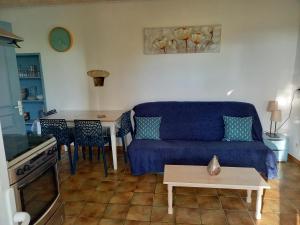 - un salon avec un canapé bleu et une table dans l'établissement la serenité, à Saint-Vivien-de-Monségur