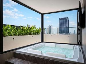 uma banheira com vista para o horizonte da cidade em Novotel Bangkok on Siam Square em Bangkok