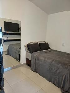 1 Schlafzimmer mit 2 Betten und einem Flachbild-TV in der Unterkunft casa com bela vista em Bragança Paulista in Bragança Paulista