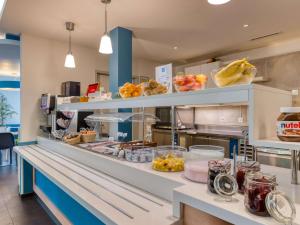 una cocina con una barra con comida. en ibis budget Hotel Luzern City, en Lucerna