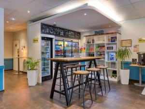 un bar en una tienda con taburetes en una habitación en ibis budget Hotel Luzern City en Lucerna